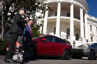 X Æ A-Xii, the son of White House Senior Advisor, Tesla and SpaceX CEO Elon Musk, plays with a toy car as Musk and U.S. President Donald Trump speak alongside a Tesla Model Y and a Cyber Truck on the South Lawn of the White House.