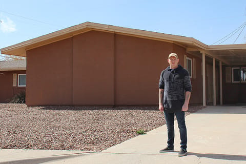 Former Army Sergeant Johny Dudek stands in front of his previous home in El Paso, Texas.