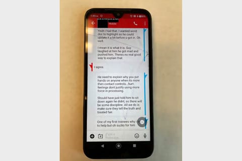 A photo of a smartphone with a text messaging exchange open. The sender's text reads: "I mean it is what it is. Guy laughed at him he got mad and pushed him. Theres no real good way to explain that". The receiver replies: "I agree". Sender continues: "He need to explain why you put hands on anyone when its more then contact controls...hurt feelings dont justify using more force in processing. Should have just told him to sit down again he didnt, so there will be some discipline. All we do is make sure they tell the truth and treated fair."