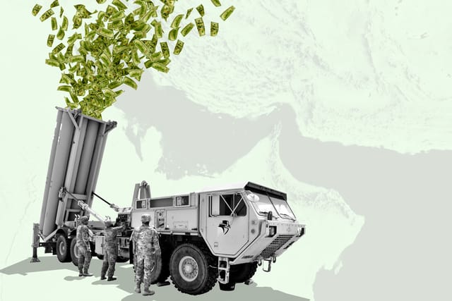 Editorial collage. Three U.S. Army Soldiers check a Terminal High Altitude Area Defense (THAAD) launcher with hundreds of dollar bills shooting out of it. An aerial view of the Strait of Hormuz is visible in the background.