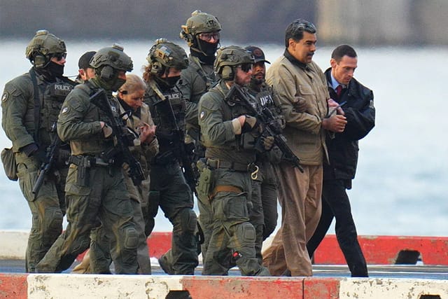Nicolas Maduro and his wife, Cilia Flores, are seen in handcuffs after landing at a Manhattan helipad, escorted by heavily armed Federal agents as they make their way into an armored car en route to a Federal courthouse in Manhattan on January 5, 2026 in New York City.