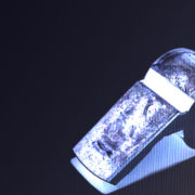 A blue whistle against a black backdrop.